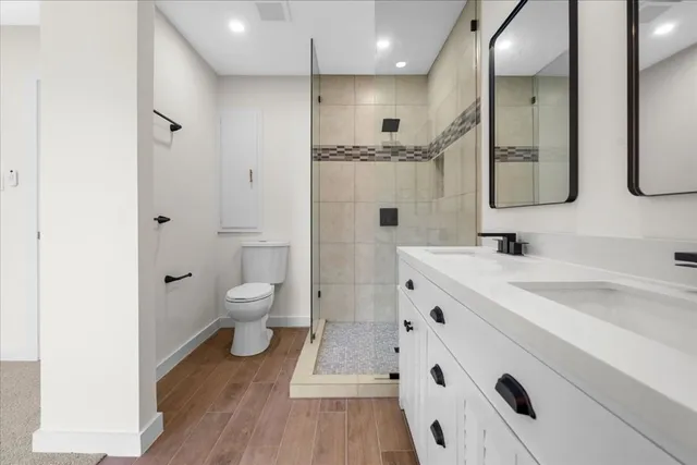 a bathroom with a double vanity sink mirror and toilet