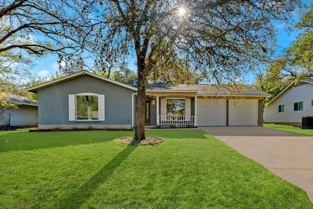 a view of a house with a yard and tree