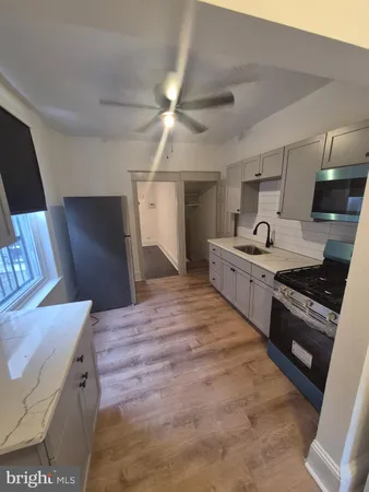 a large kitchen with stainless steel appliances a stove a refrigerator and a fireplace