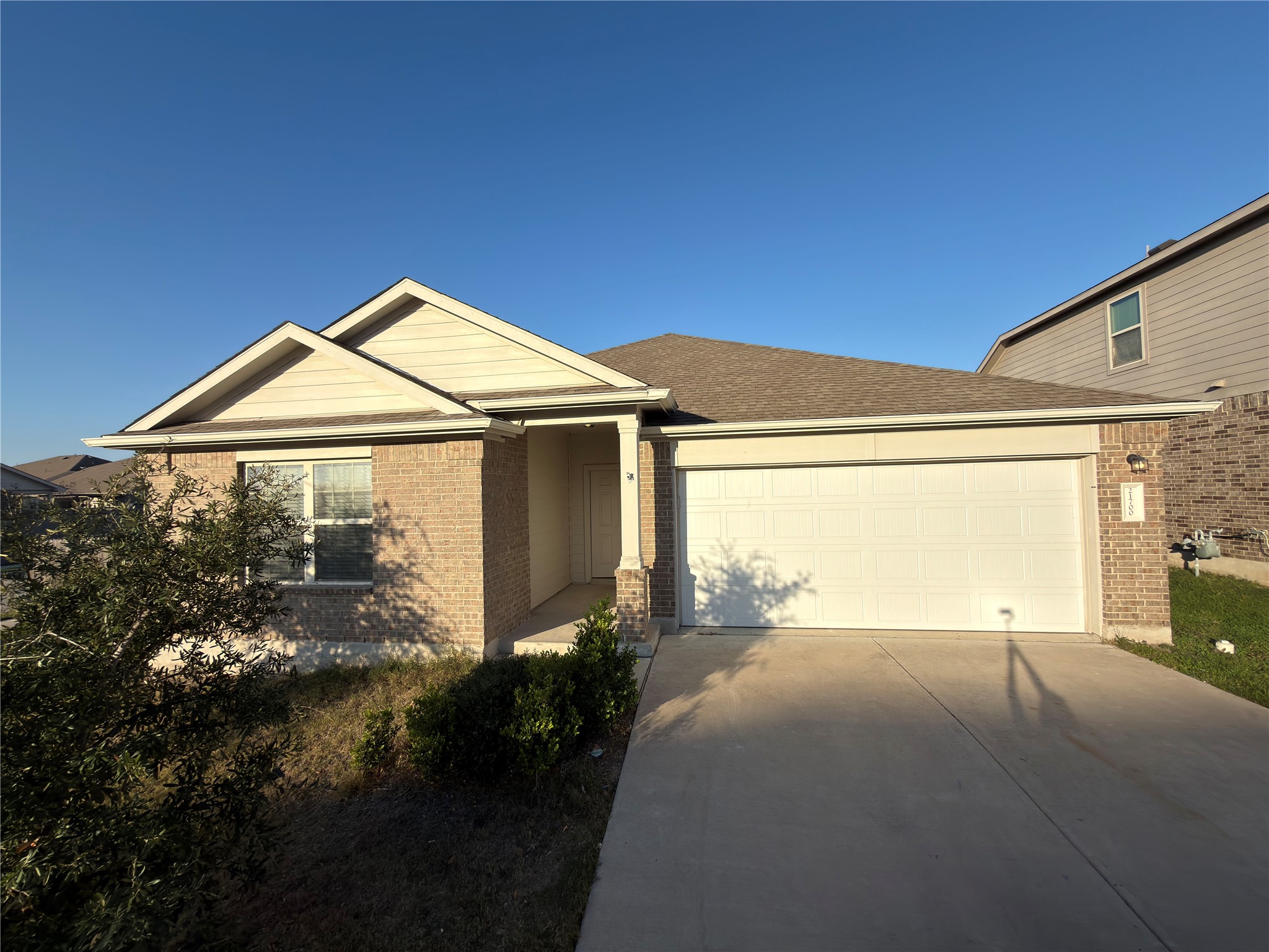 21700 Urraca Lane Pflugerville, TX 78660 - Photo 2 of 40 View of front of property with driveway, brick siding, and an attached garage