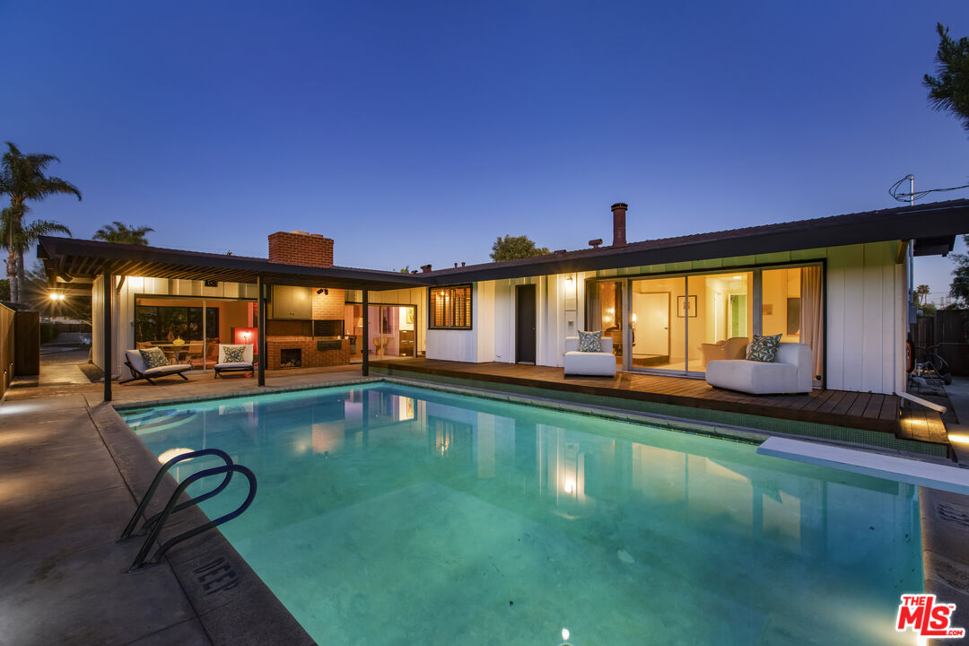 a swimming pool view with a outdoor seating