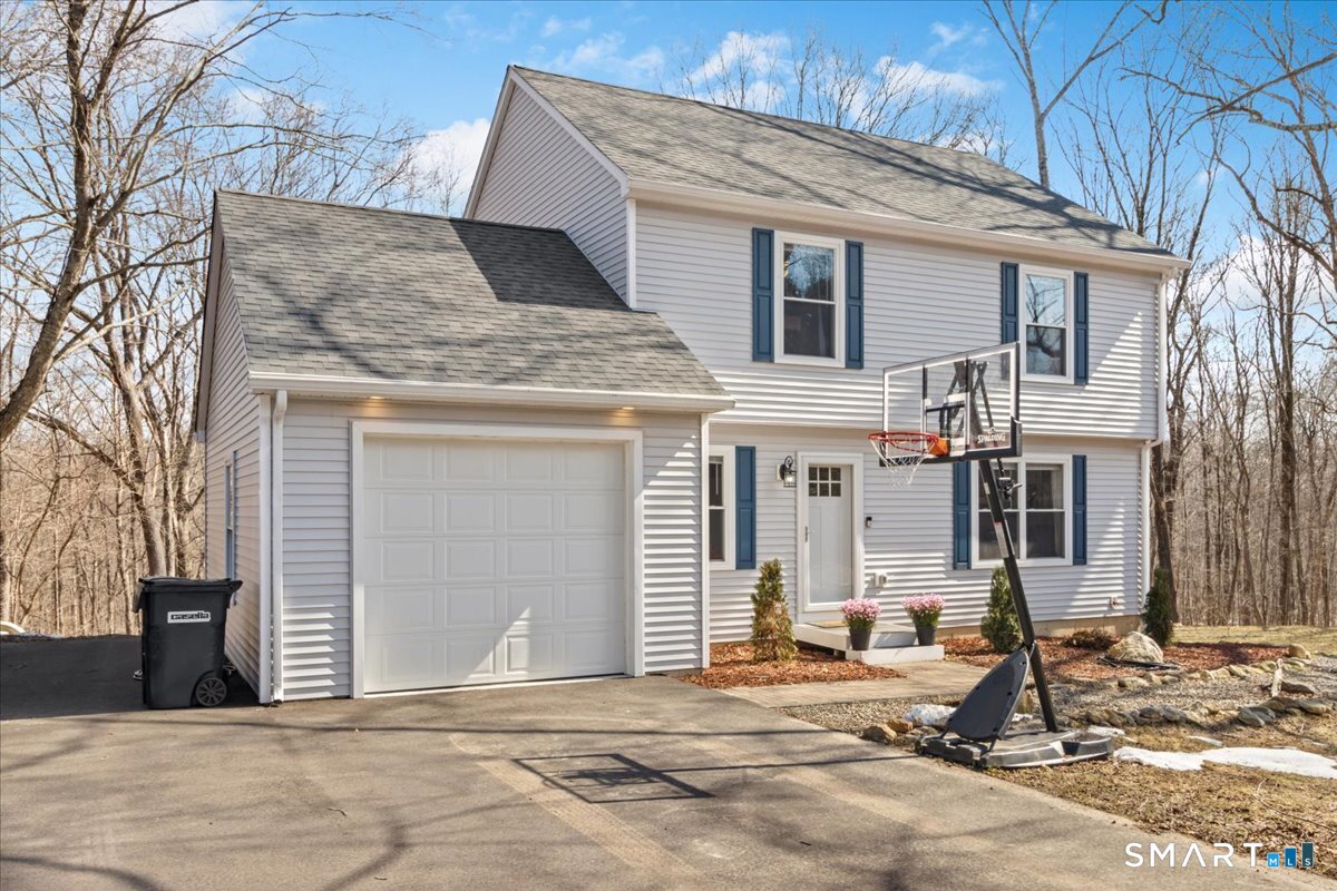 a front view of a house with basket ball court and wooden fence