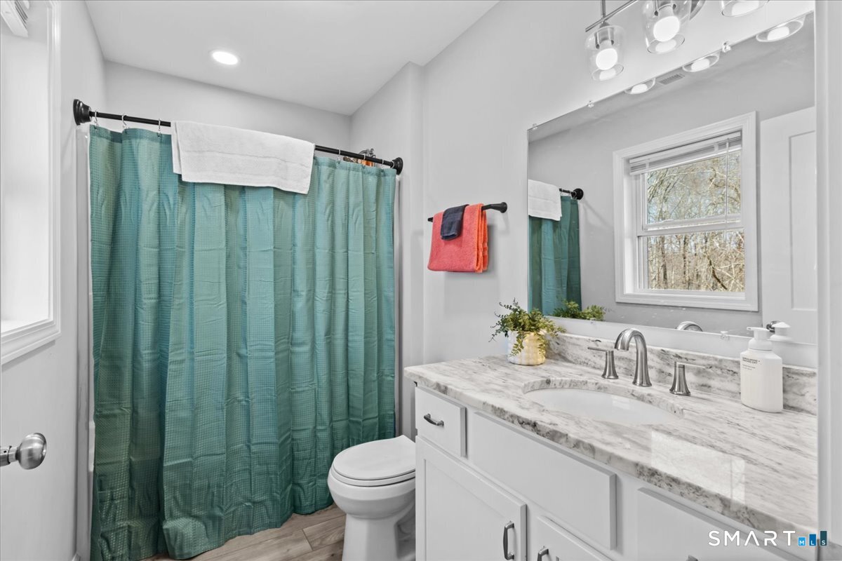 26 2nd Street Lebanon, CT 06249 - Photo 17 of 37 a bathroom with a granite countertop sink a toilet and shower
