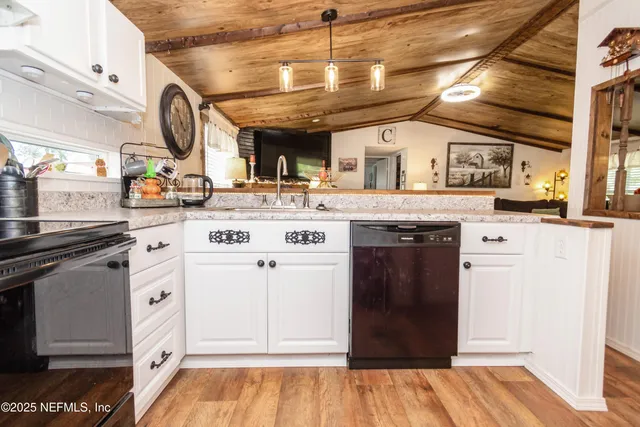 a kitchen with stainless steel appliances granite countertop a stove and a wooden floors