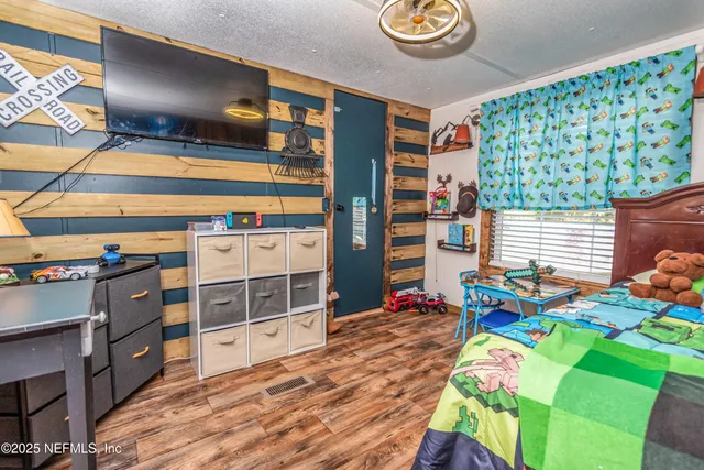 a view of a bedroom with baby crib and furniture