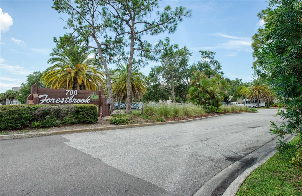 700 Starkey Road, Unit 1145 Largo, FL 33771 - Photo 55 of 63 a sign board with flower plants and large trees