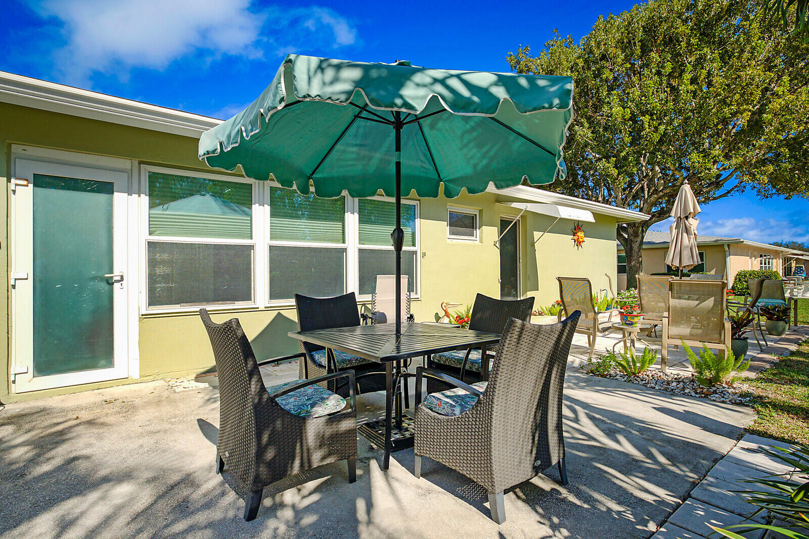 170 High Point Boulevard, Unit B Boynton Beach, FL 33435 - Photo 25 of 26 a view of a patio with table and chairs under an umbrella