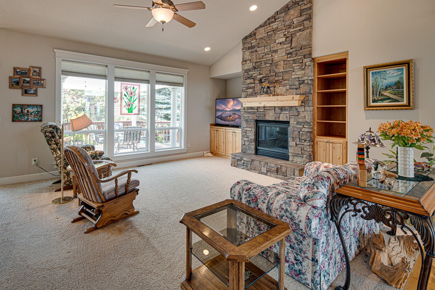 3956 Southwest Timber Avenue Redmond, OR 97756 - Photo 12 of 54 Living room with vaulted ceiling, stacked rock fireplace, built-ins and lots of windows.