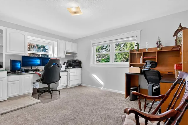 a view of a workspace with furniture and a window