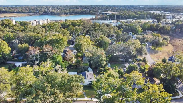 an aerial view of a houses with a yard and lake view