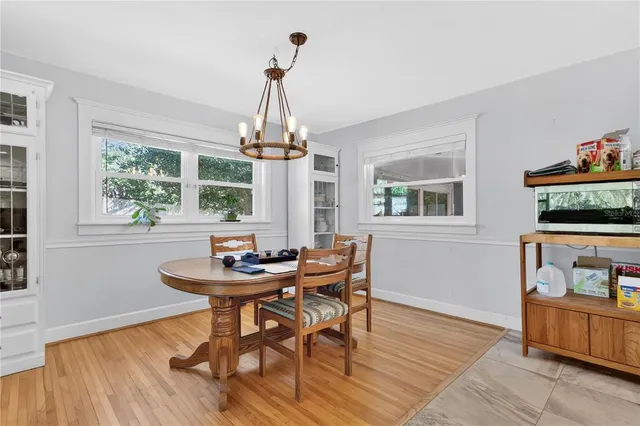 a dining room with furniture a chandelier and wooden floor