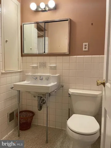 a bathroom with a toilet a sink and mirror