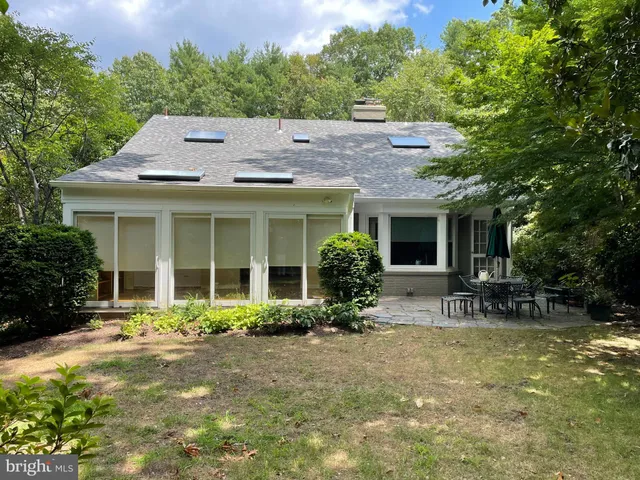 a backyard of a house with yard table and chairs