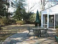 a view of a patio with table and chairs and floor to ceiling window