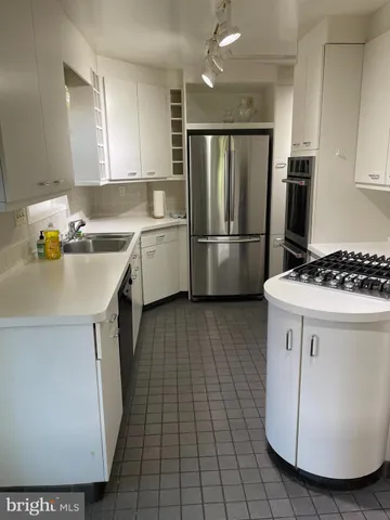 a kitchen with a sink a refrigerator and cabinets