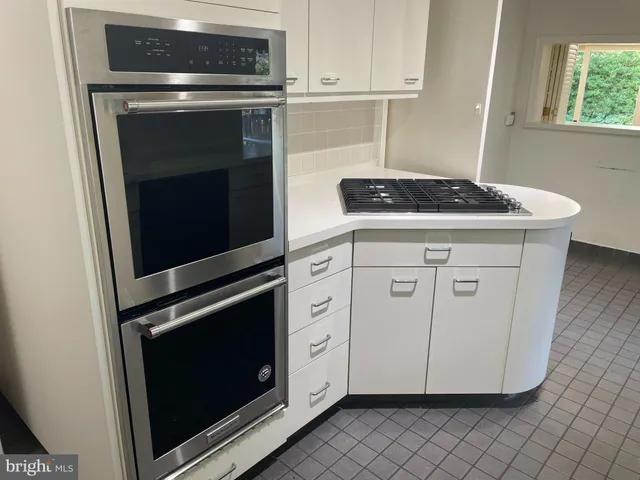 a kitchen with granite countertop white cabinets stainless steel appliances and a sink