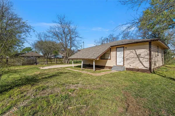 a view of a house with backyard and trees