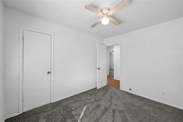 an empty room with fan and a ceiling fan