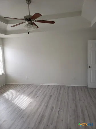 a view of a room with wooden floor fan and a window