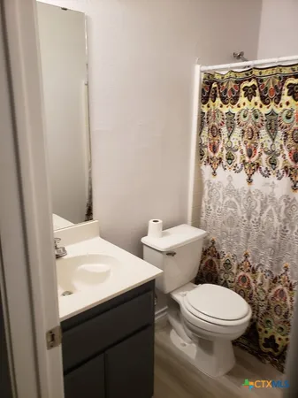 a bathroom with a toilet and a shower curtain