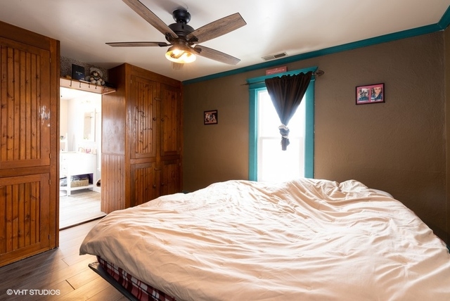 6688 Rich Road DeKalb, IL 60115 - Photo 8 of 27 a bedroom with a large bed and a chandelier