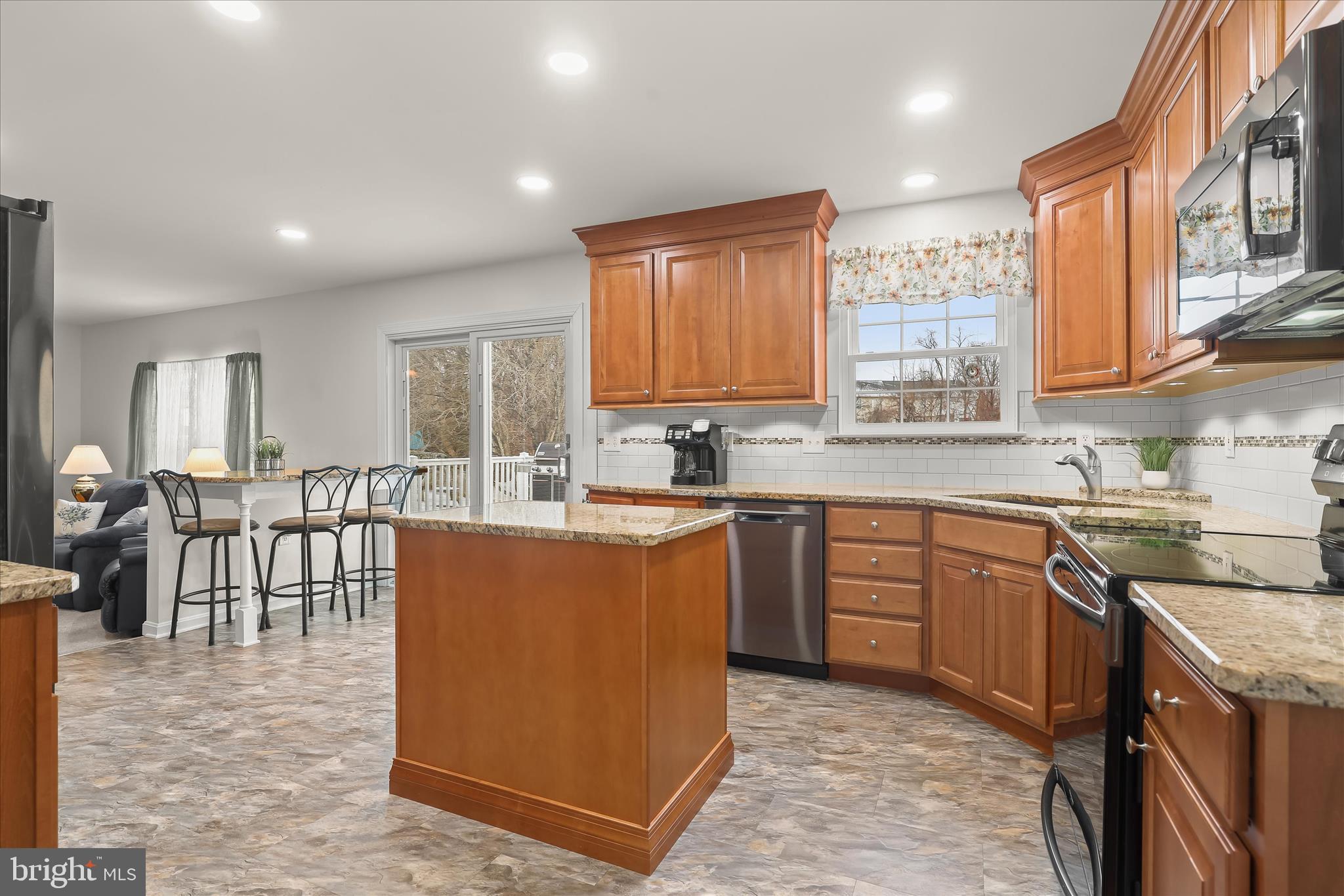 6463 Tydings Road Sykesville, MD 21784 - Photo 15 of 104 a kitchen with stainless steel appliances granite countertop a stove top oven a sink dishwasher a dining table and chairs with wooden floor