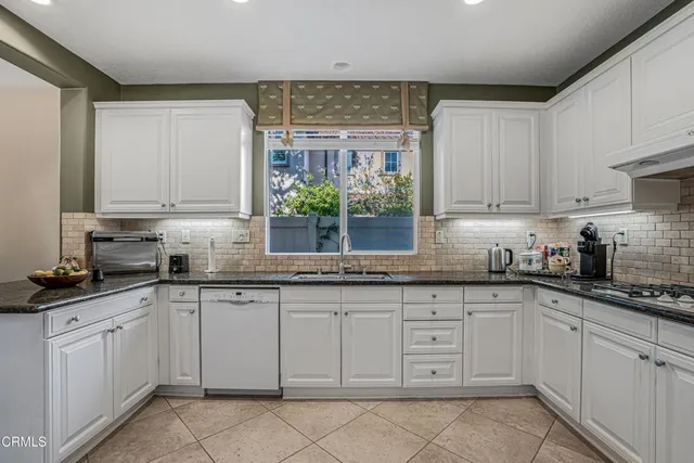 a kitchen with white cabinets and white appliances