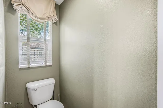 a bathroom with a toilet a sink and a window