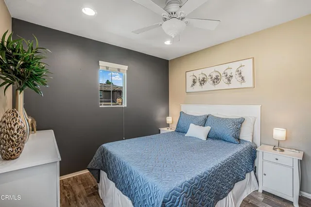 a bedroom with a large bed and a potted plant