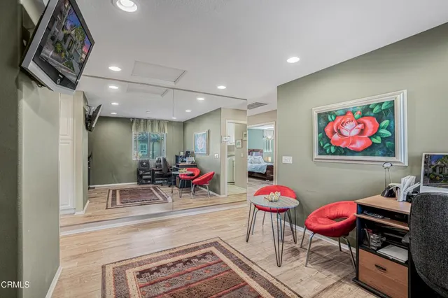a living room with furniture a rug and wall paintings