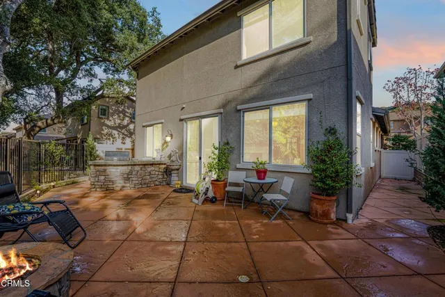 a view of a patio with dining table and chairs under an umbrella