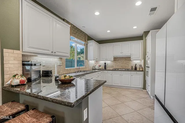 a kitchen with stainless steel appliances granite countertop a sink stove and cabinets
