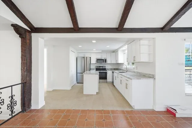 a kitchen with stainless steel appliances granite countertop a sink and a refrigerator