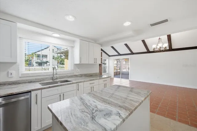 a kitchen with granite countertop a sink window and cabinets