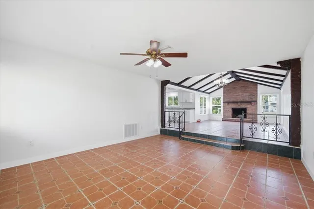 an empty room with windows and ceiling fan