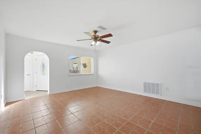an empty room with fan and windows
