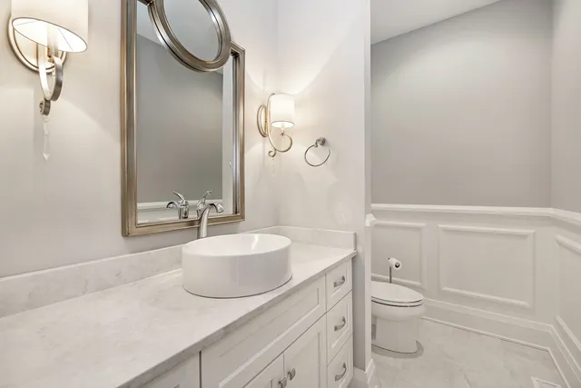 a bathroom with a granite countertop sink a toilet and a mirror