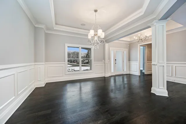 a view of a livingroom with wooden floor a ceiling fan and windows