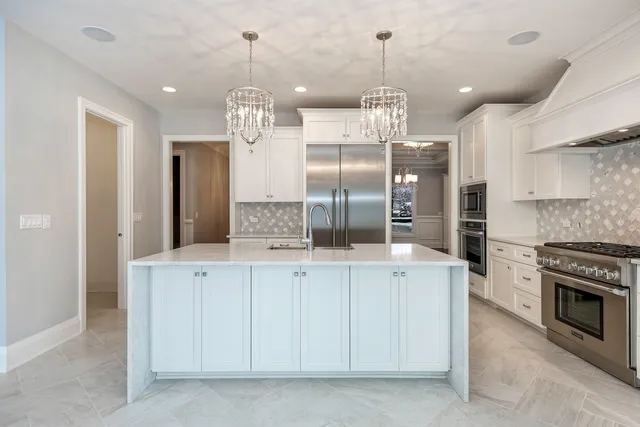 a kitchen with stainless steel appliances granite countertop a sink a stove and a refrigerator