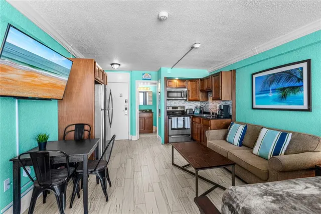 a living room with furniture and a dining table with kitchen view