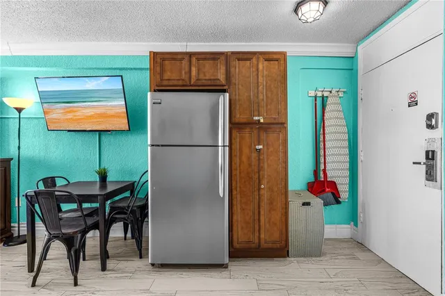 a kitchen with stainless steel appliances granite countertop a refrigerator and a wooden cabinets