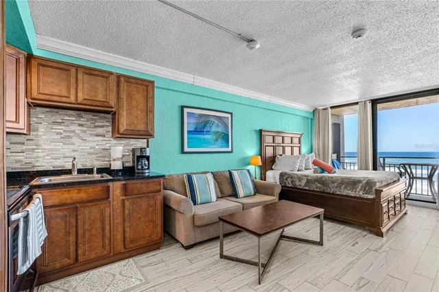 a living room with furniture and a kitchen area