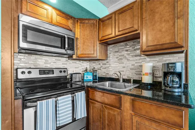 a kitchen with stainless steel appliances granite countertop a stove microwave and cabinets