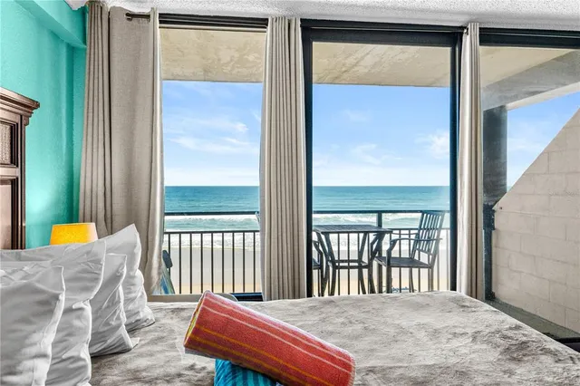 a bedroom with a balcony a bed and a window