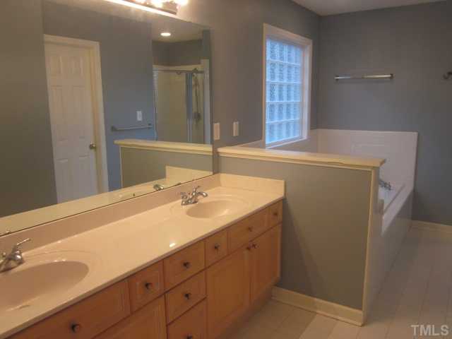 10024 Baileywick Road Raleigh, NC 27613 - Photo 22 of 25 Master bath features tile floors, cultured marble counter tops with 2 vanities, jetted corner garden tub, tile shower with 2 shower heads & bench seat!