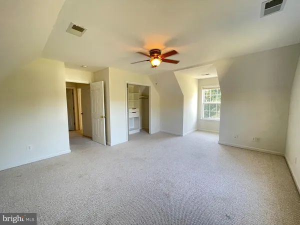 an empty room with windows and refrigerator