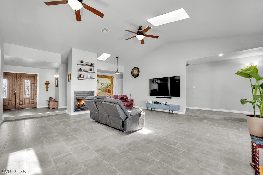420 North Racetrack Road Henderson, NV 89015 - Photo 16 of 52 Enter this living space featuring a cozy fireplace, skylights, and durable tile flooring throughout.