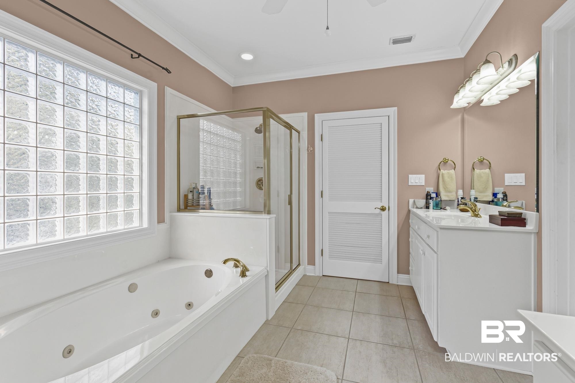 32191 River Road Orange Beach, AL 36561 - Photo 22 of 46 Bathroom with vanity, a whirlpool tub, a stall shower, crown molding, and light tile patterned floors