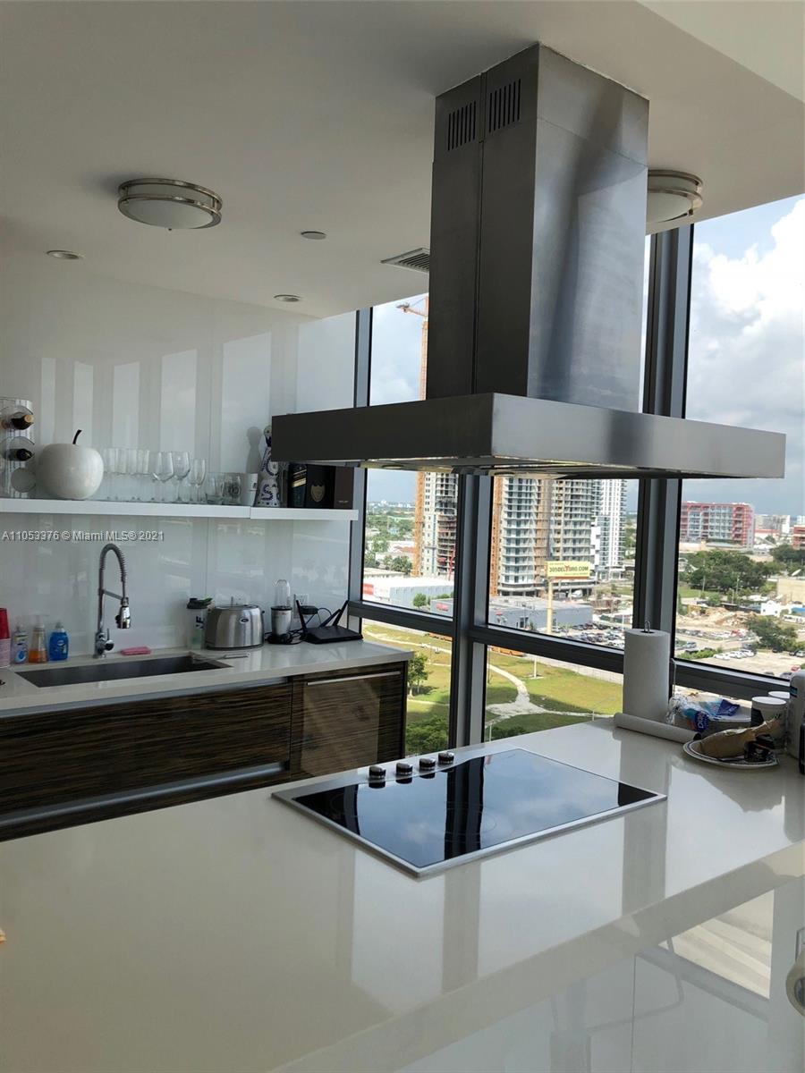 1100 Biscayne Boulevard, Unit 1505 Miami, FL 33132 - Photo 9 of 15 a kitchen with stainless steel appliances granite countertop a sink and a stove