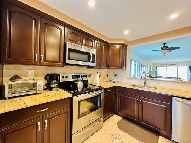 a kitchen with kitchen island a sink stainless steel appliances and cabinets